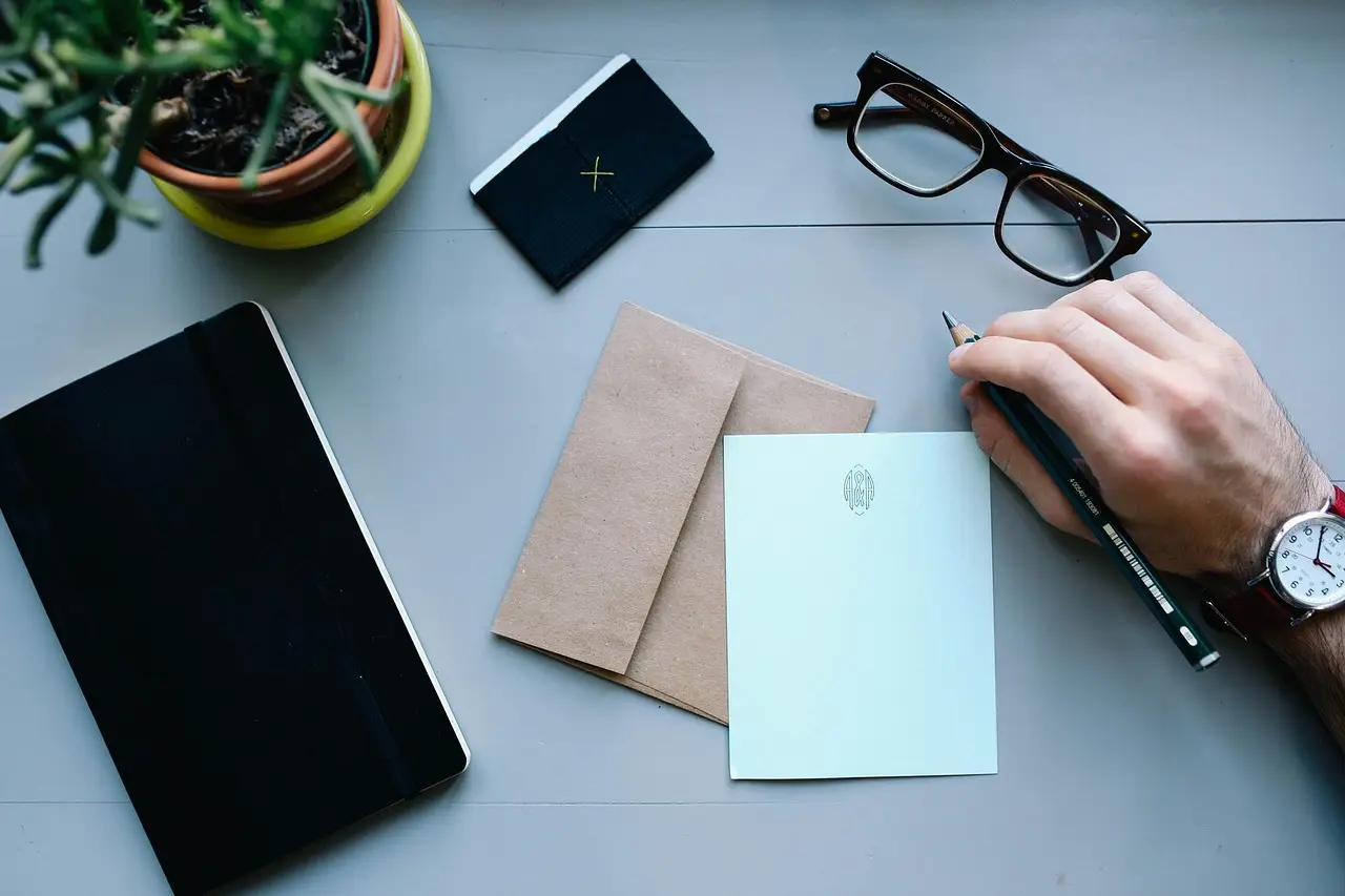 A person working at a desk with a laptop and a wristwatch