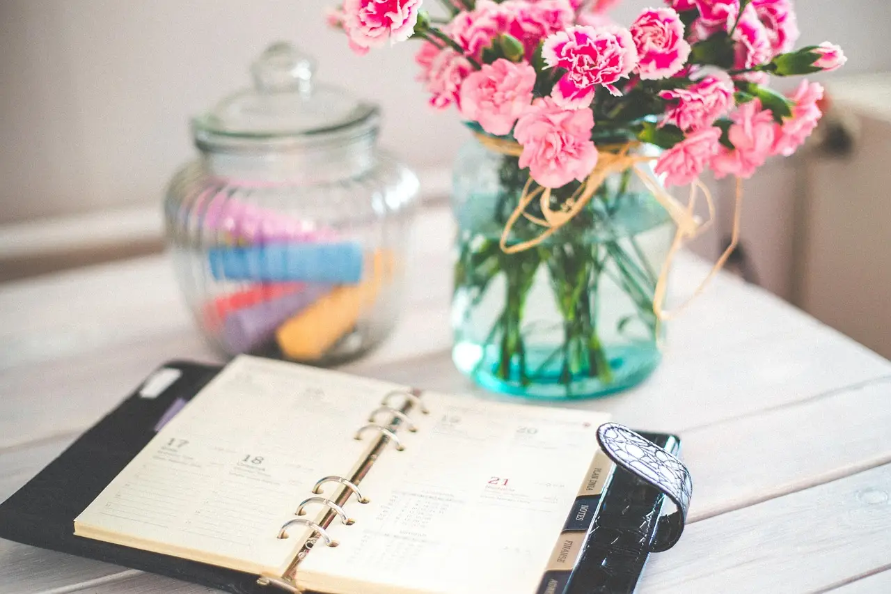 An open planner and calendar on a desk for organizing tasks